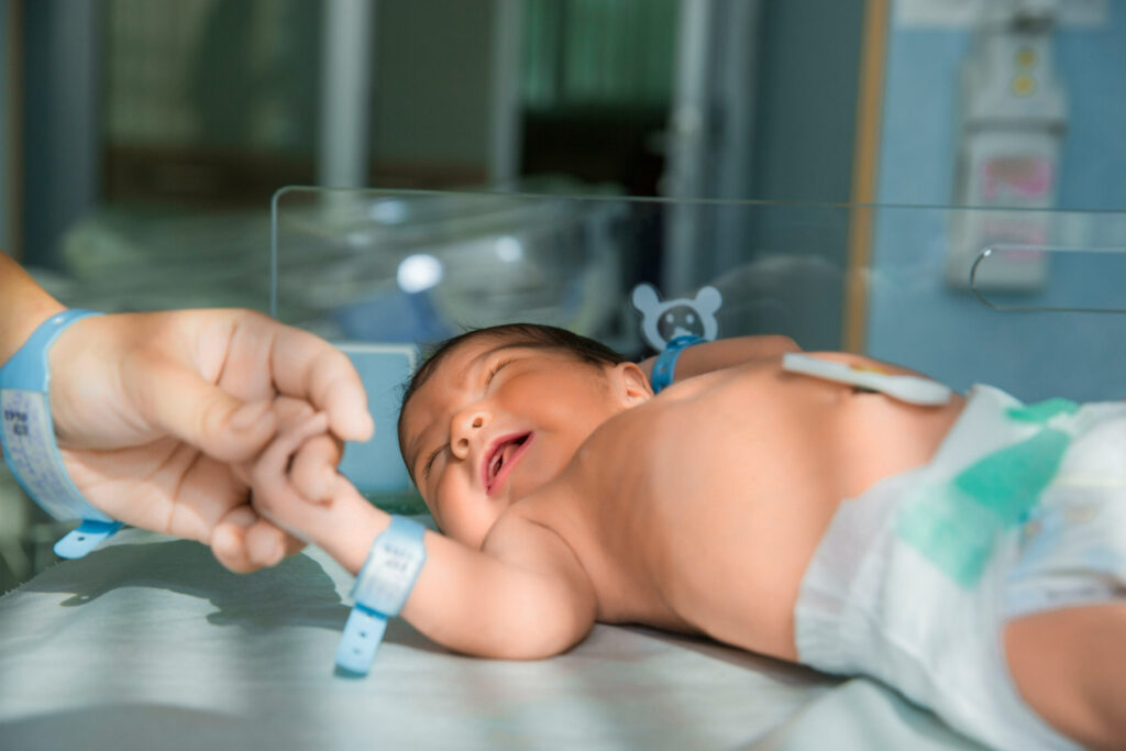 A neonatal nurse guiding parents during the expert-led transition from NICU to home care.
