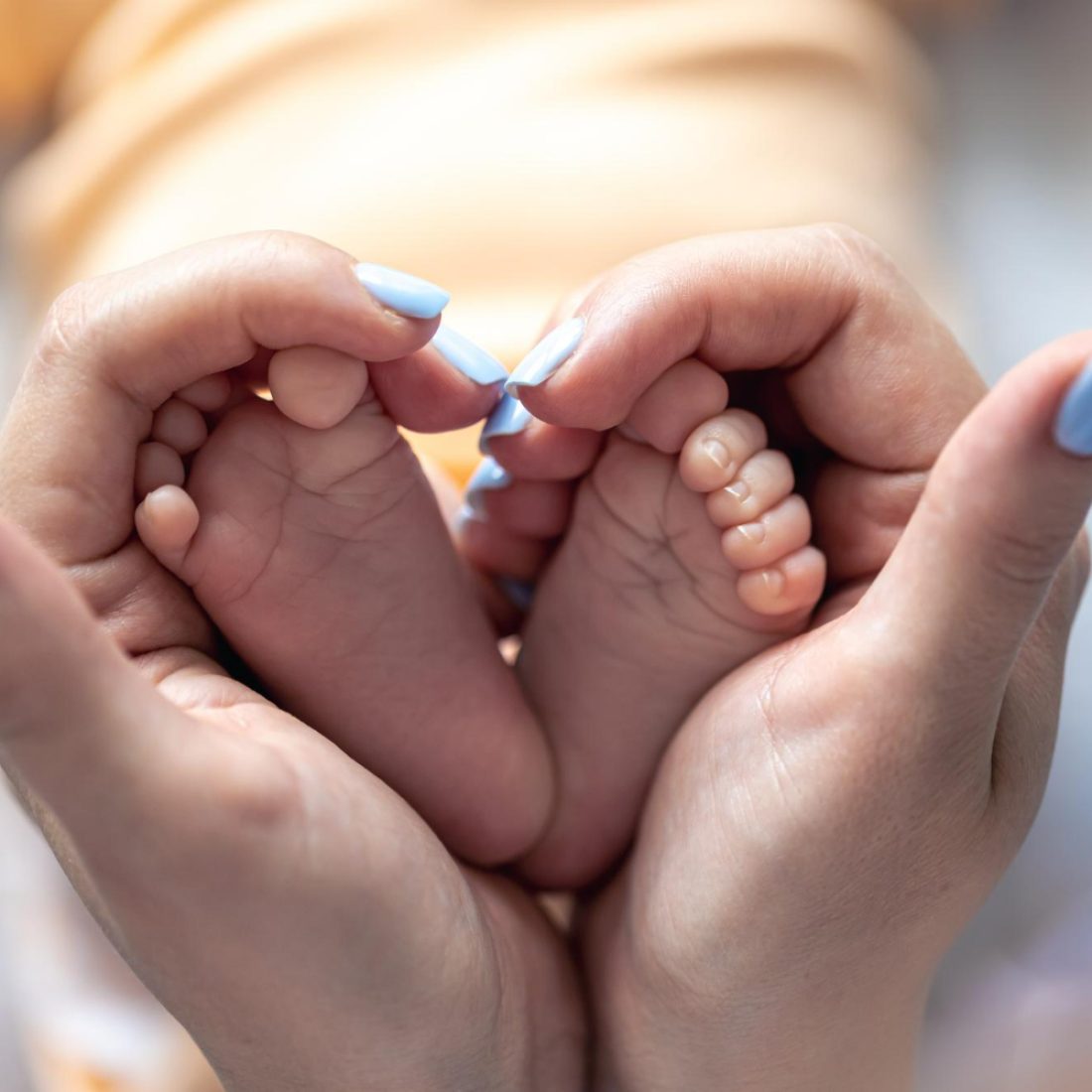 A nurse gently caring for a newborn baby at home after NICU discharge.