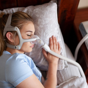Patient using a CPAP machine for sleep apnea care during nighttime rest.