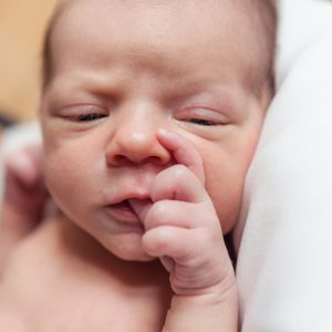 A neonatal nurse caring for a newborn in a specialized neonatal intensive care unit (NICU)